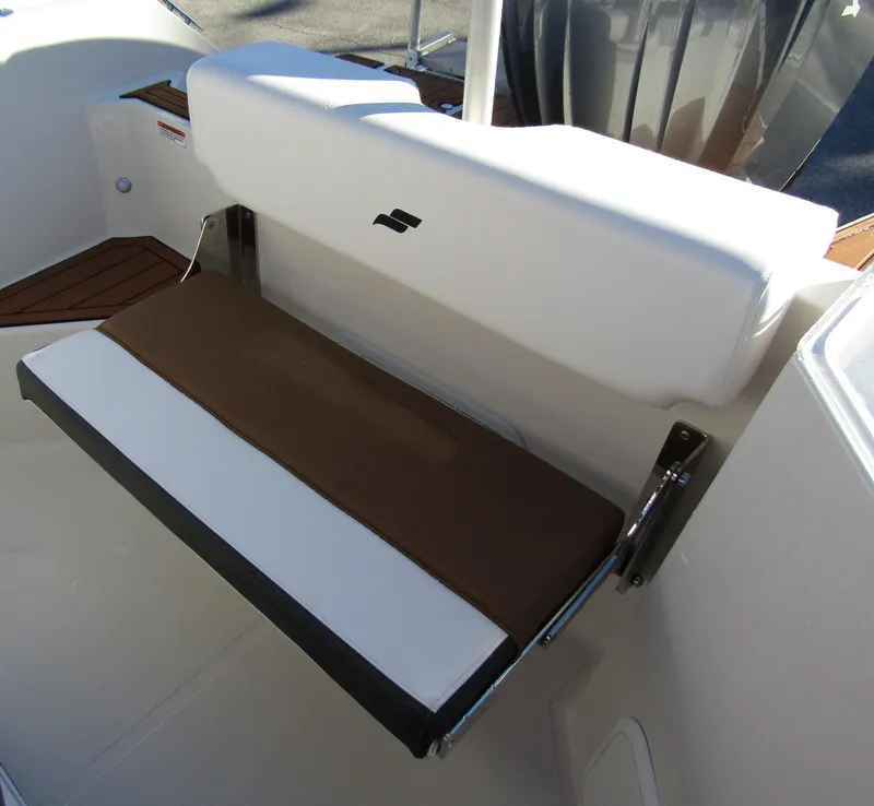 Slide: The Image of 2024 Starcraft SVX 231 OB CC boat seat with white and brown cushions. - 24