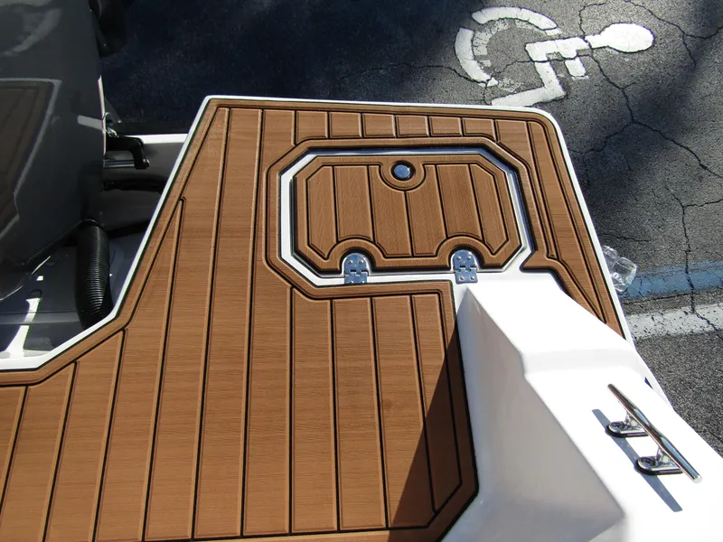 Slide: The Image of 2024 Starcraft SVX 231 OB CC boat deck with wood finish and storage compartment. - 28