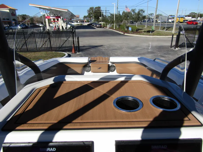 Slide: The Image of 2024 Starcraft SVX 231 OB CC boat dashboard with cup holders and navigation equipment. - 19