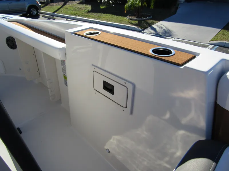 Slide: The Image of 2024 Starcraft SVX 231 OB CC boat interior with cup holders and storage compartment. - 14