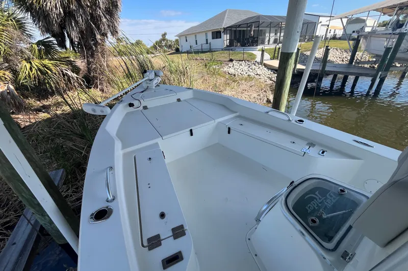 Slide: The Image of 2022 KenCraft 239 Bay Rider boat docked near a waterfront home. - 12