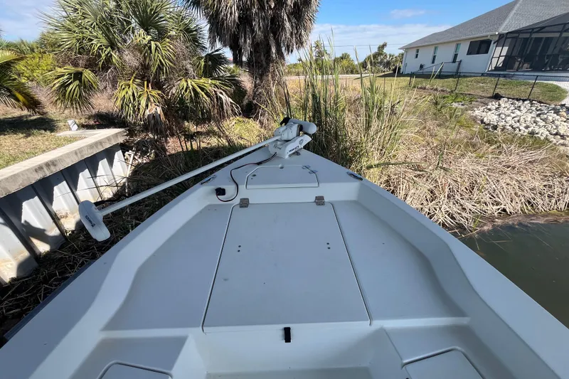 Slide: The Image of 2022 KenCraft 239 Bay Rider boat docked near lush vegetation and a house. - 13