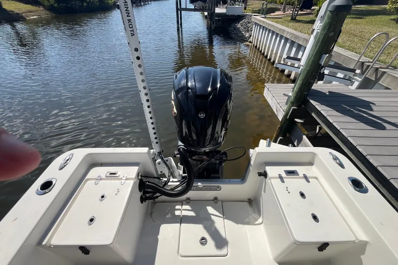 Slide: The Image of 2022 KenCraft 239 Bay Rider boat with motor, docked on a calm waterway. - 17
