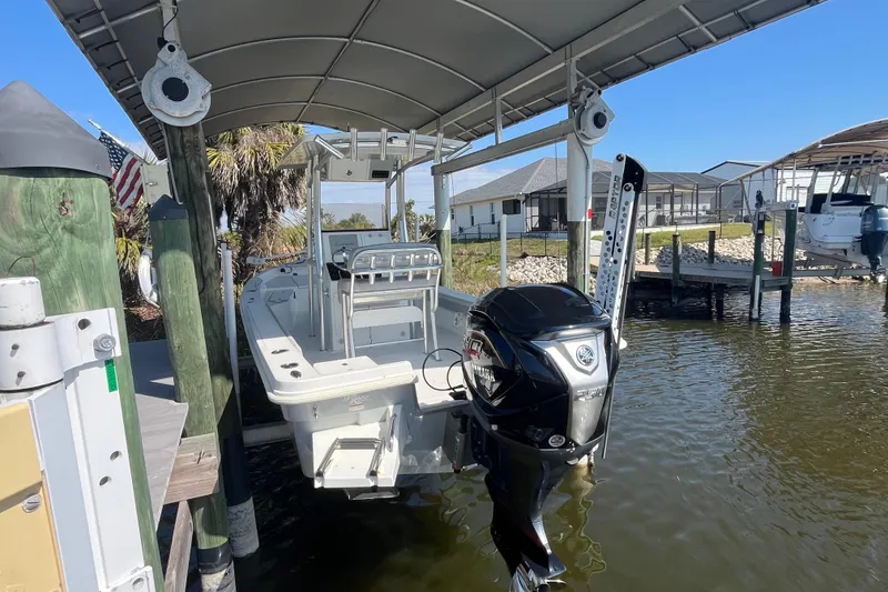 Slide: The Image of 2022 KenCraft 239 Bay Rider boat docked under a canopy with Yamaha outboard motor. - 4
