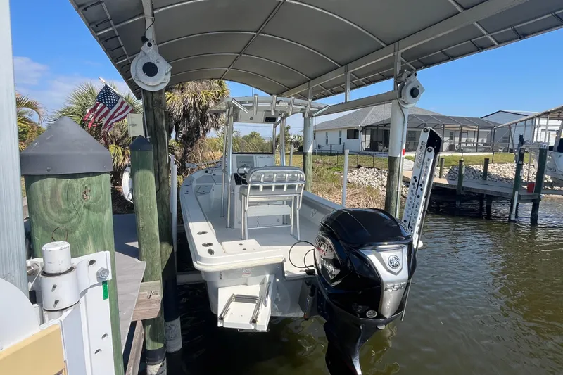 Slide: The Image of 2022 KenCraft 239 Bay Rider boat docked under a canopy with outboard motor. - 5