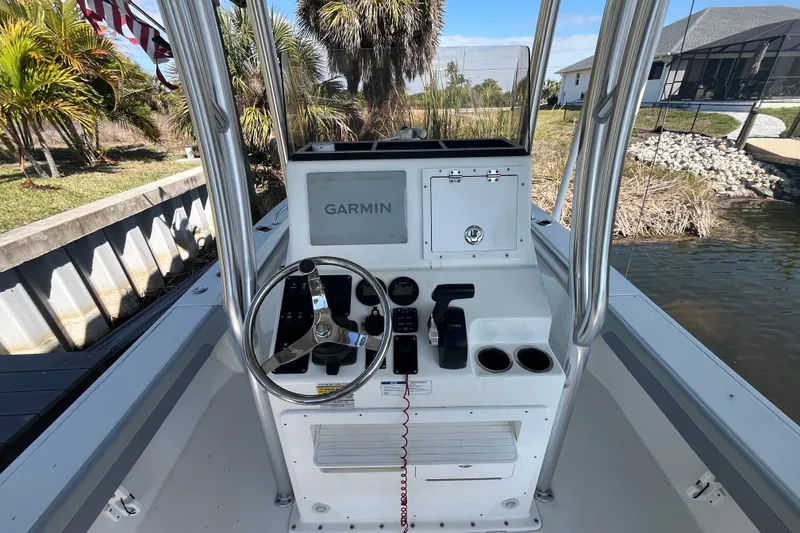 Slide: The Image of 2022 KenCraft 239 Bay Rider boat console with Garmin navigation system, docked near palm trees. - 8