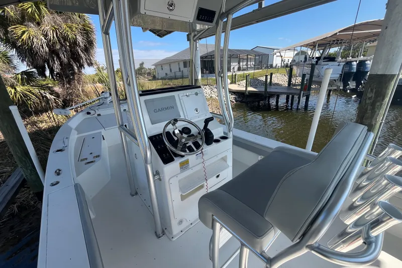 Slide: The Image of 2022 KenCraft 239 Bay Rider boat interior with Garmin navigation system, docked near palm trees. - 9