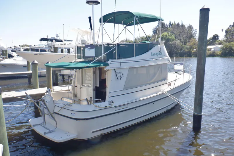 The Image of 2004 Camano 31 Troll boat docked in a marina with green canopy. - 1