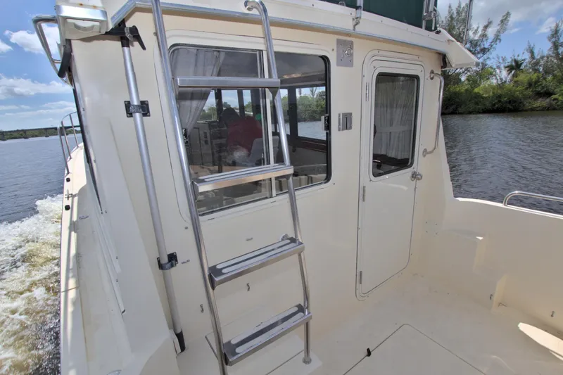 Slide: The Image of 2004 Camano 31 Troll boat exterior with ladder and door, cruising on a sunny day. - 11
