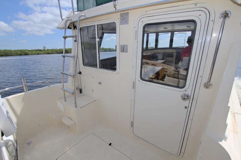 Slide: The Image of 2004 Camano 31 Troll boat deck with ladder and cabin door, on a sunny day. - 12
