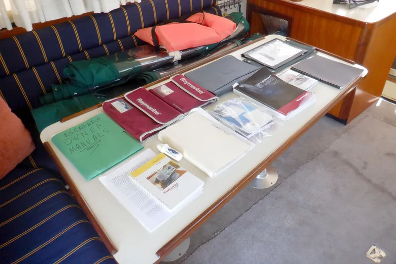 Slide: The Image of Owner manuals and documents on table inside 2004 Camano 31 Troll boat cabin. - 17