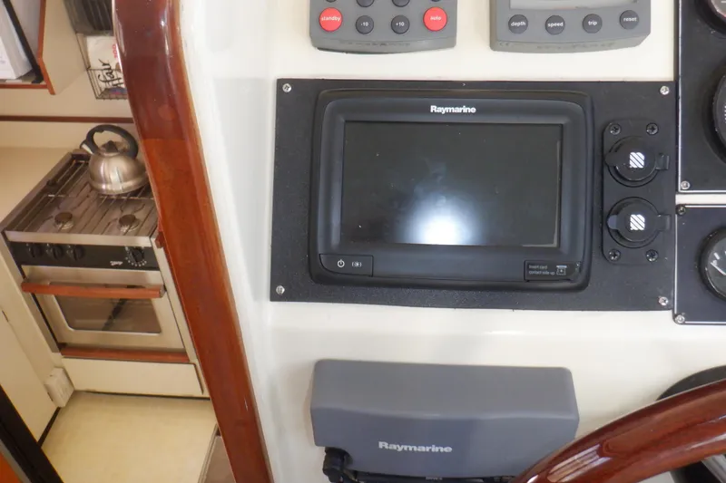 Slide: The Image of 2004 Camano 31 Troll interior with Raymarine navigation system and kitchen stove. - 24
