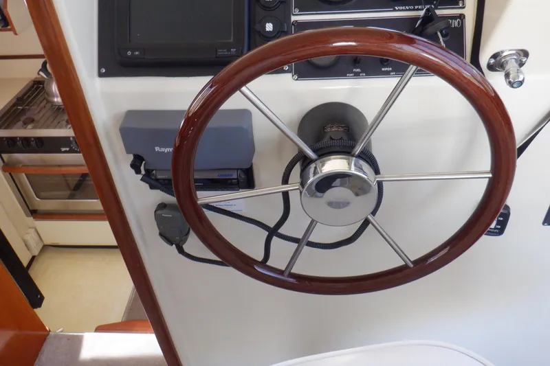 Slide: The Image of Steering wheel of a 2004 Camano 31 Troll boat, featuring navigation controls. - 25