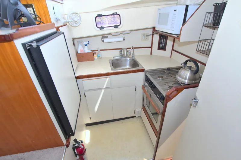 Slide: The Image of Compact kitchen in a 2004 Camano 31 Troll boat with stove, sink, and microwave. - 28