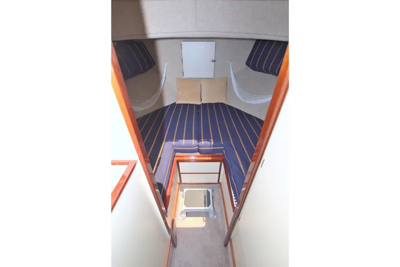 Slide: The Image of 2004 Camano 31 Troll cabin interior with striped bedding and wooden accents. - 35