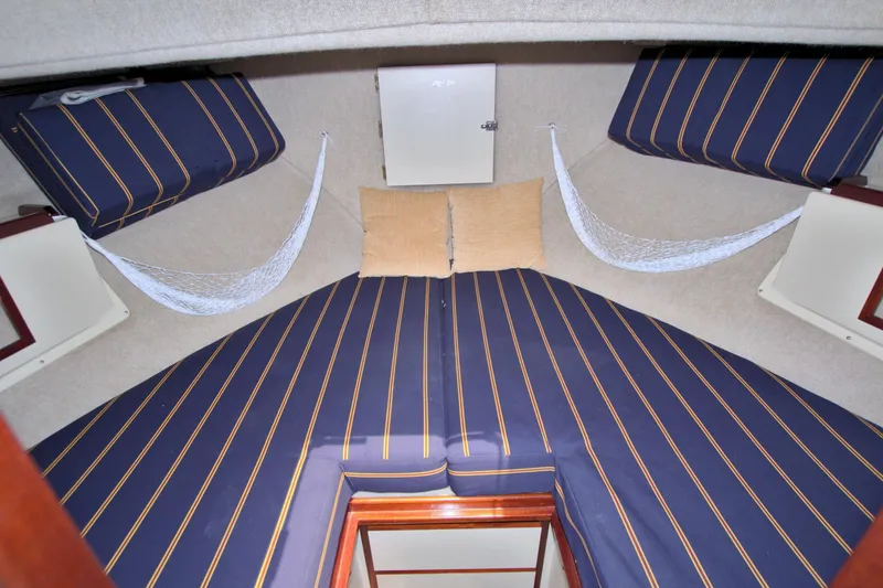 Slide: The Image of Interior cabin of 2004 Camano 31 Troll with striped cushions and storage nets. - 37