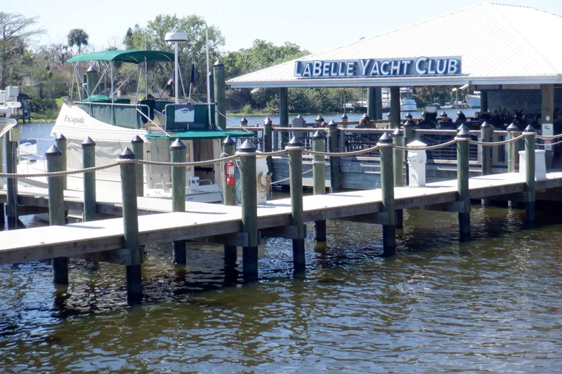 Slide: The Image of 2004 Camano 31 Troll docked at Labelle Yacht Club, surrounded by calm waters. - 45