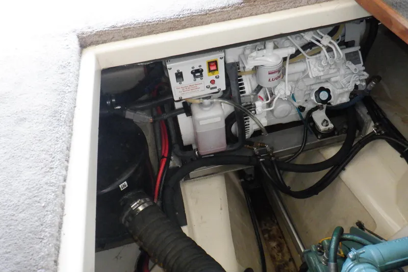 Slide: The Image of Engine compartment of a 2004 Camano 31 Troll boat, showcasing mechanical components and wiring. - 49
