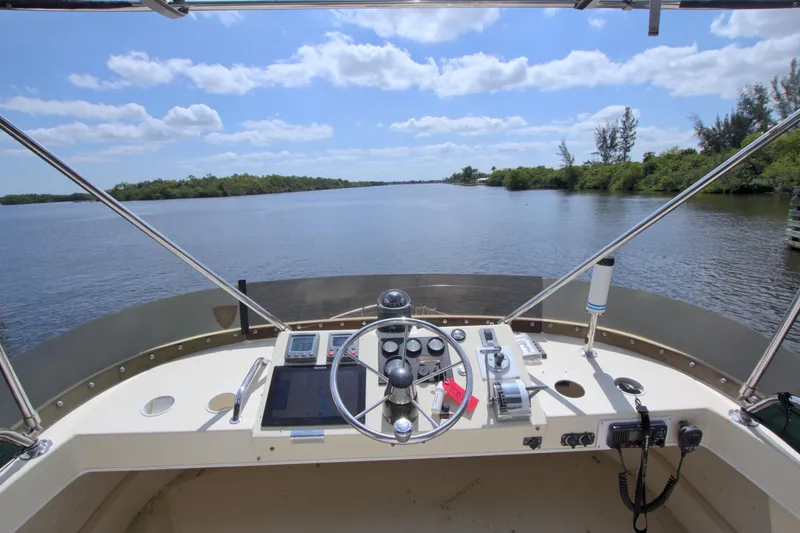 Slide: The Image of Helm view of 2004 Camano 31 Troll boat on a serene waterway. - 9