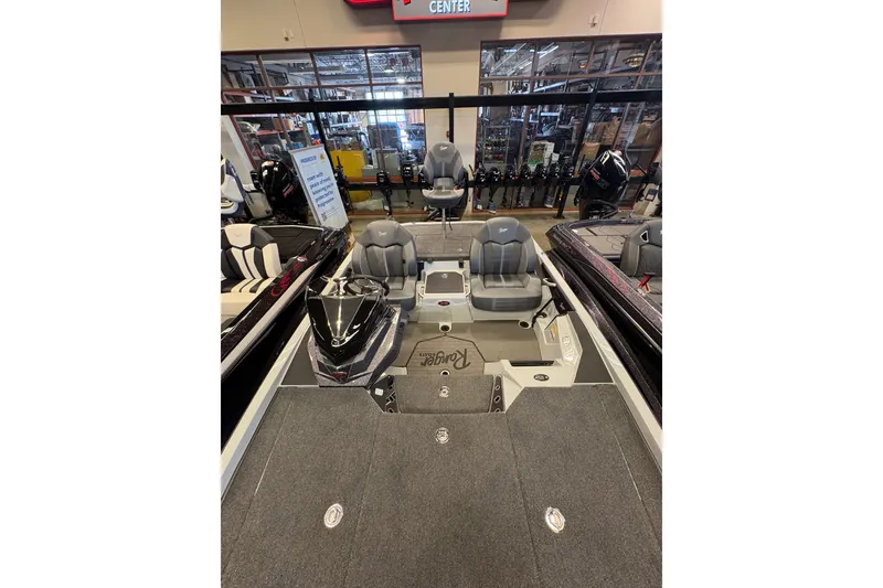Slide: The Image of 2026 Ranger Z519R boat interior with gray seating and carpeted deck in showroom. - 10