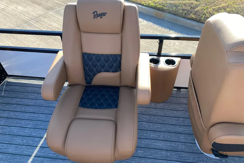 Slide: The Image of 2026 Ranger 220FC boat seat with tan and blue upholstery, featuring cup holders. - 10
