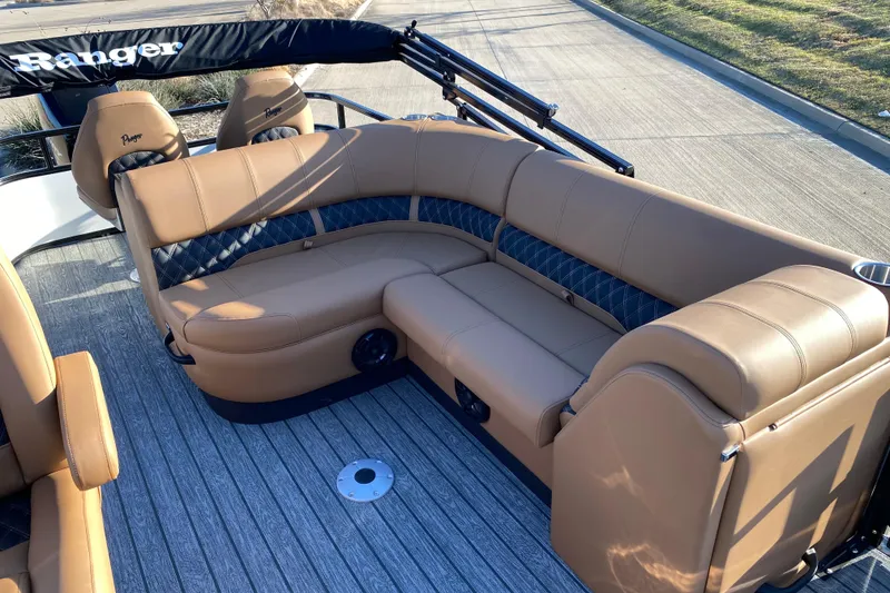 Slide: The Image of 2026 Ranger 220FC boat interior with tan and black seating on a wooden deck. - 13