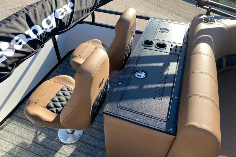 Slide: The Image of 2026 Ranger 220FC boat interior with tan seating and console, featuring cup holders and storage. - 17