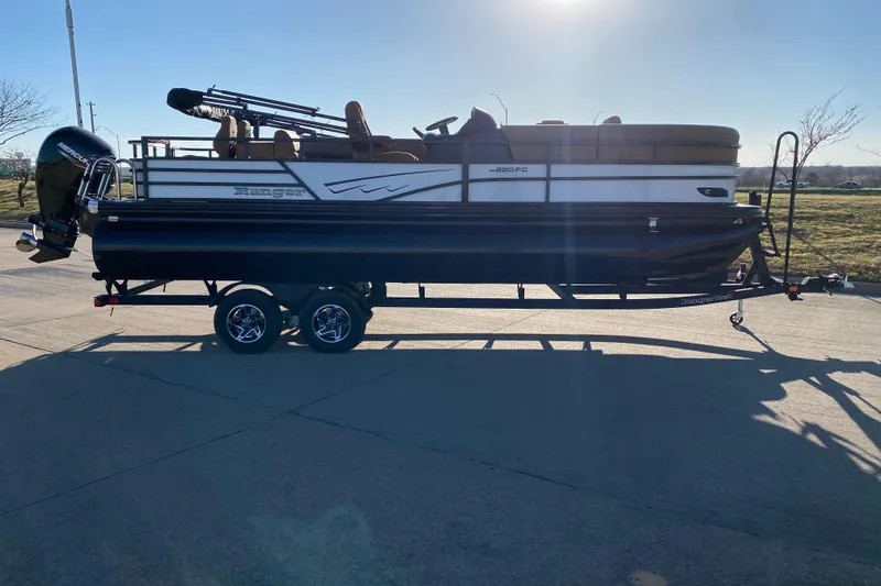 Slide: The Image of 2026 Ranger 220FC pontoon boat on trailer, parked on sunny day. - 3
