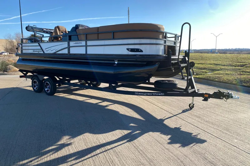 Slide: The Image of 2026 Ranger 220FC pontoon boat on trailer, parked on concrete surface. - 4