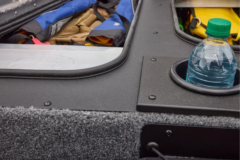 Slide: The Image of 2026 Tracker Pro Team 175 boat interior with open storage compartments and cup holders. - 23