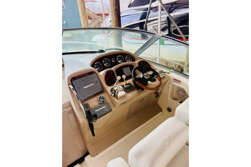 Slide: The Image of 2002 Sea Ray Sundancer 320 helm with Raymarine electronics and wood-accented steering wheel. - 10
