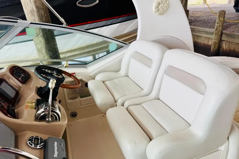 Slide: The Image of 2002 Sea Ray Sundancer 320 cockpit with white leather seats and steering wheel. - 12