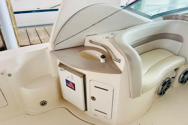 Slide: The Image of 2002 Sea Ray Sundancer 320 boat interior with seating, mini fridge, and sink. - 14