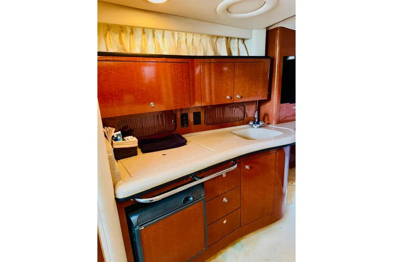 Slide: The Image of Luxurious 2002 Sea Ray Sundancer 320 yacht interior with elegant wooden cabinetry and compact kitchenette. - 16