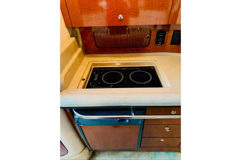 Slide: The Image of 2002 Sea Ray Sundancer 320 galley with stove and cabinetry. - 17