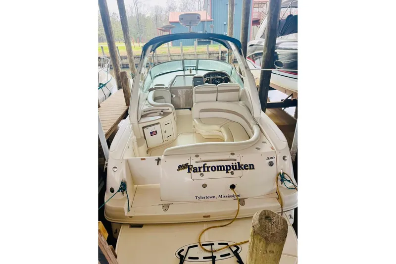 Slide: The Image of 2002 Sea Ray Sundancer 320 docked, featuring spacious seating and sleek design. - 4