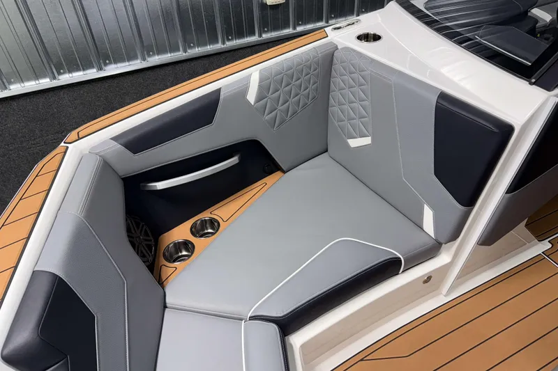Slide: The Image of 2026 Nautique Super Air Nautique GS20 interior with gray and black seating, cup holders, and teak flooring. - 29