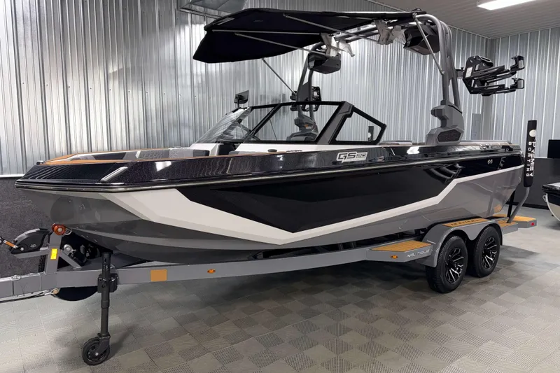 Slide: The Image of 2026 Nautique Super Air Nautique GS20 boat in showroom, sleek design, black and white exterior. - 33