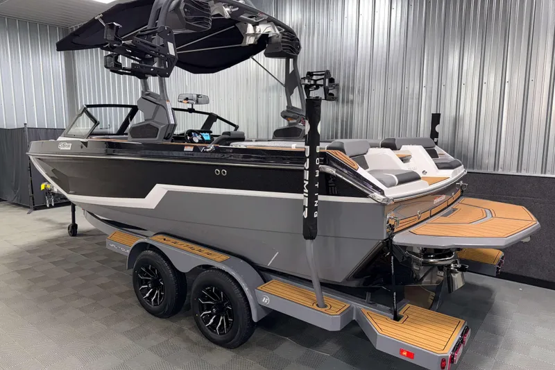 Slide: The Image of 2026 Nautique Super Air Nautique GS20 boat in showroom, sleek design, dual-axle trailer. - 36