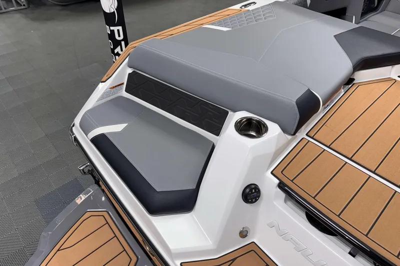 Slide: The Image of 2026 Nautique Super Air Nautique GS20 boat interior with gray and tan seating and flooring. - 4