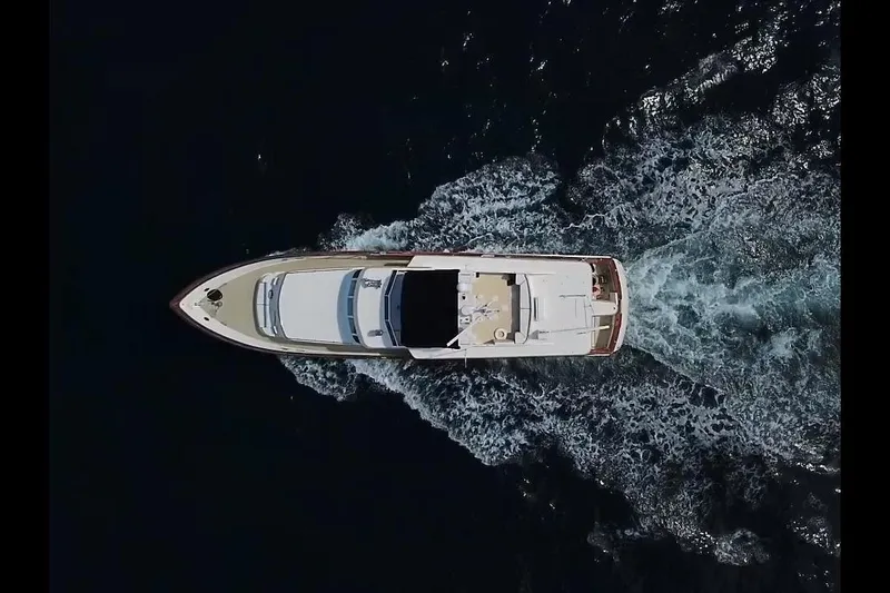 Slide: The Image of Aerial view of 1984 Broward CPMY Raised Pilothouse yacht cruising on dark water. - 143