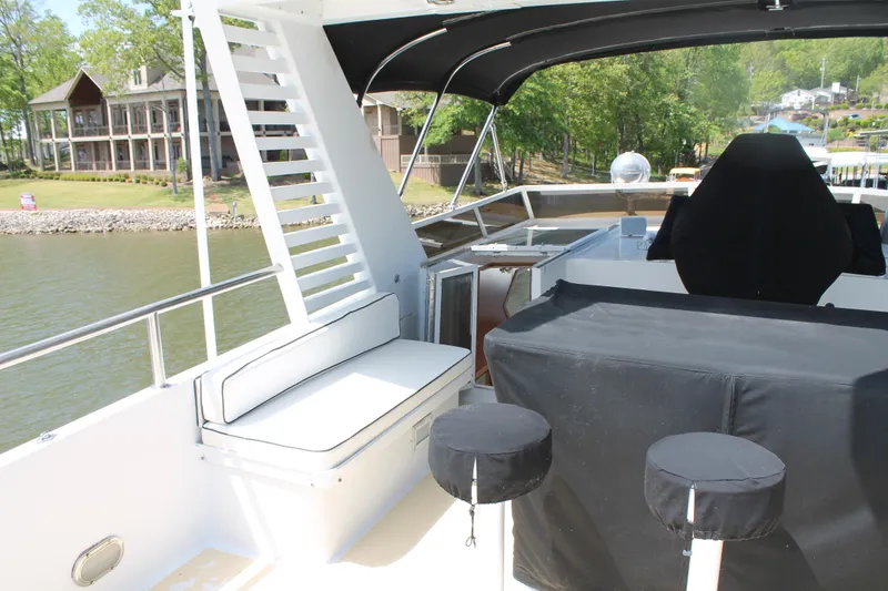 Slide: The Image of 1984 Broward CPMY yacht with covered seating area by the water. - 27