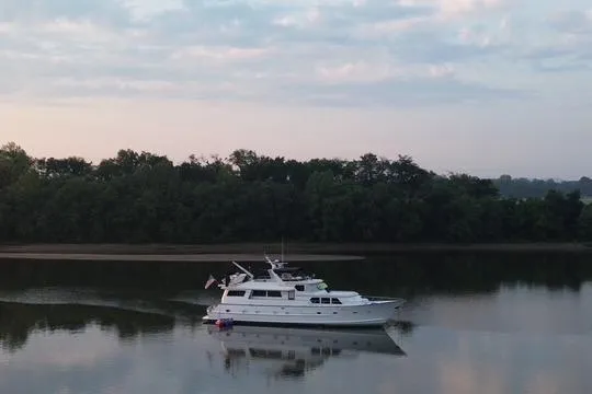 Slide: The Image of 1984 Broward CPMY Raised Pilothouse yacht cruising on calm river at sunrise. - 5