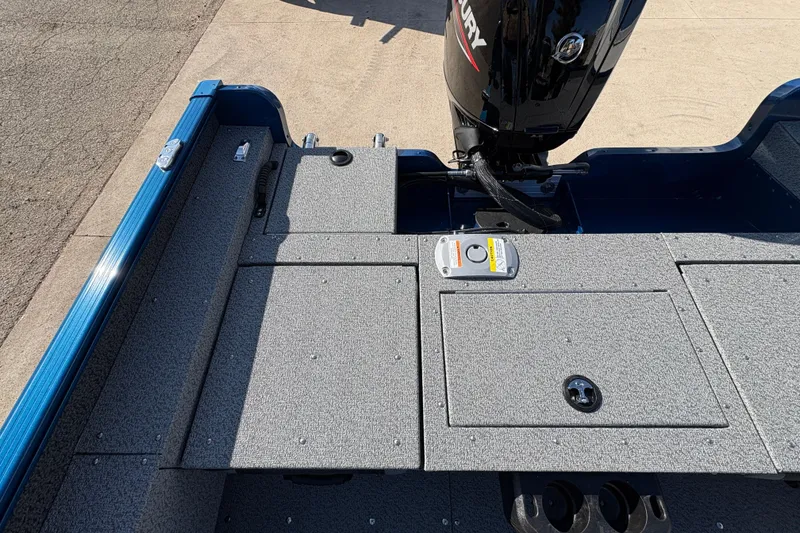 Slide: The Image of 2026 Lund 1775 Adventure SS boat deck with Mercury engine, featuring storage compartments. - 24