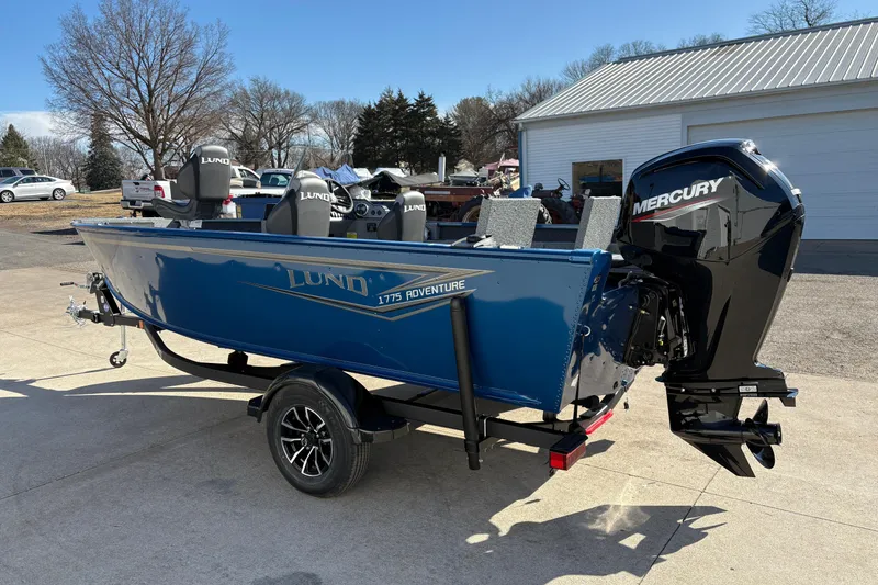 Slide: The Image of 2026 Lund 1775 Adventure SS boat with Mercury outboard motor, parked outdoors. - 3