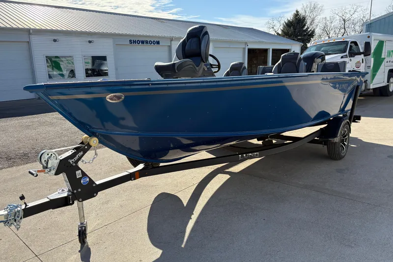 Slide: The Image of 2026 Lund 1775 Adventure SS boat in blue, parked outside a showroom. - 5