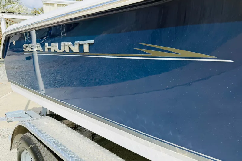 Slide: The Image of 2012 Sea Hunt Ultra 211 boat on trailer, parked outdoors under a clear sky. - 15