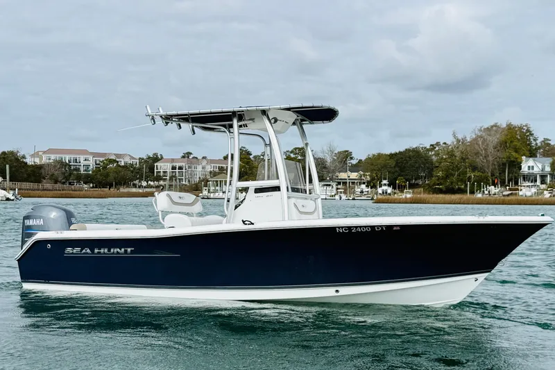 Slide: The Image of 2012 Sea Hunt Ultra 211 boat on water, featuring Yamaha engine, coastal background. - 2