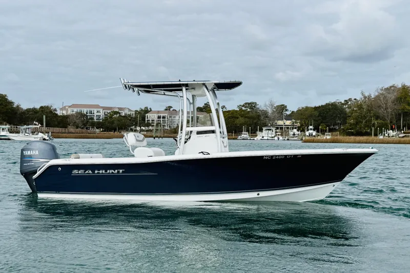 Slide: The Image of 2012 Sea Hunt Ultra 211 boat on water near a bridge. - 3
