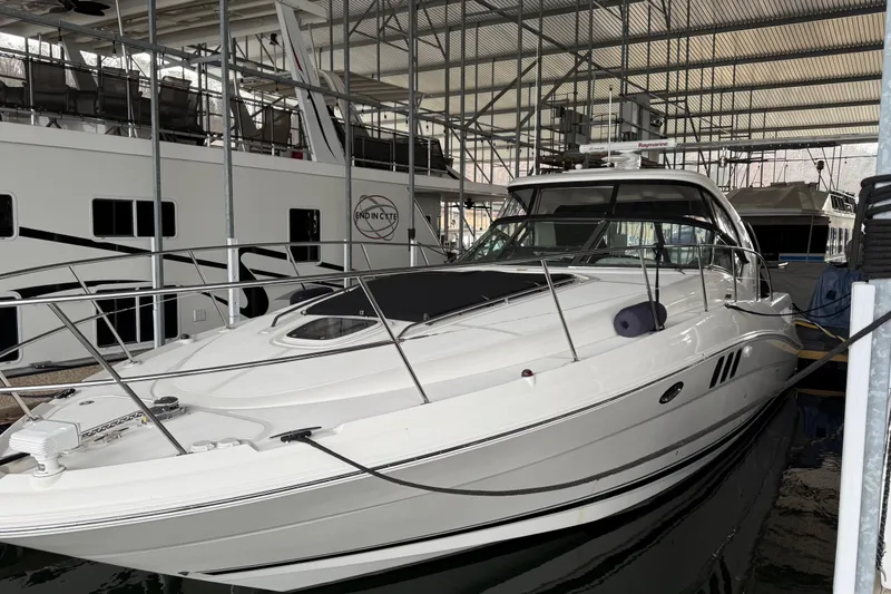 The Image of 2007 Sea Ray Sundancer 400 yacht docked in a marina under a covered structure. - 1